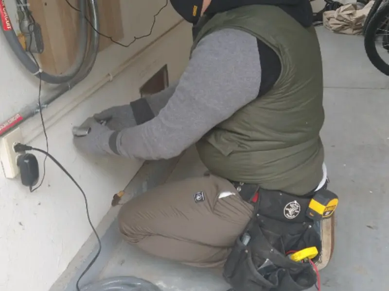 Electrician performing outlet wiring in a Monticello garage